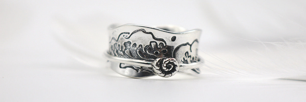 Ocean Kiss sterling silver spinner ring with a wave pattern and conch