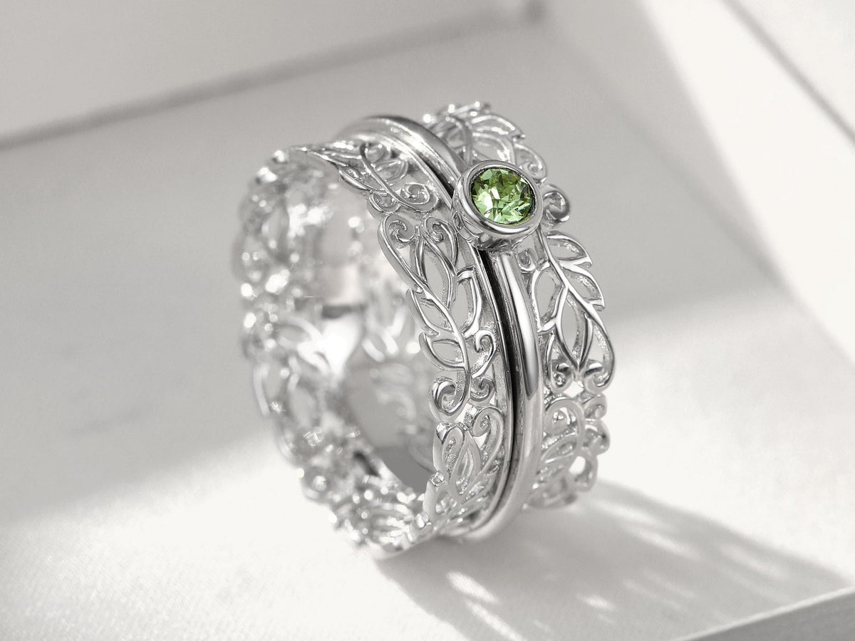 Filigree silver spinner ring with a green stone
