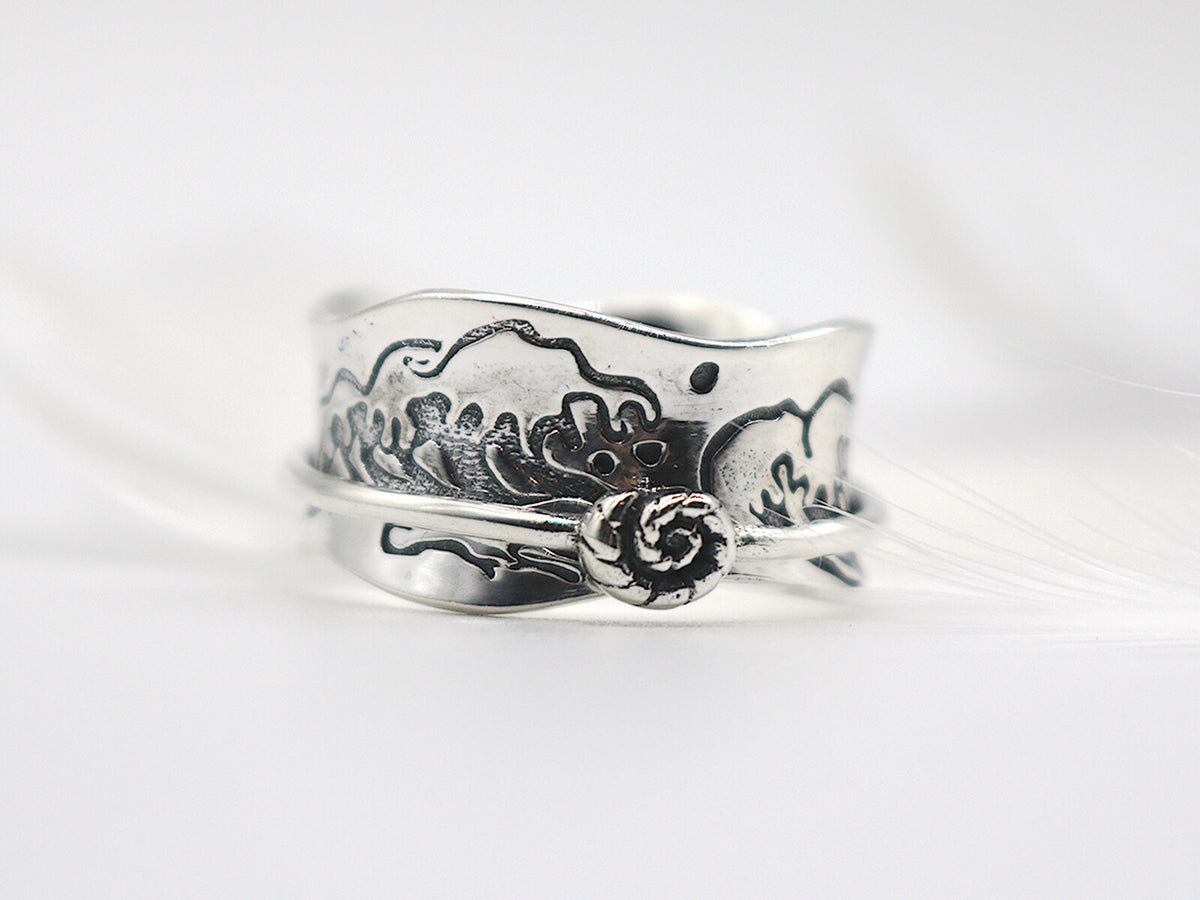 Ocean Kiss sterling silver spinner ring with a wave pattern and conch